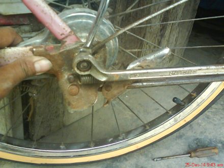 mengencangkan mur bersamaan sisi kanan dan sisi kiri as roda belakang