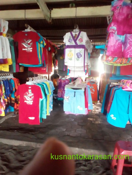 Kita bisa membeli souvenir berupa kaos /pakaian anak dewasa di pantai ini