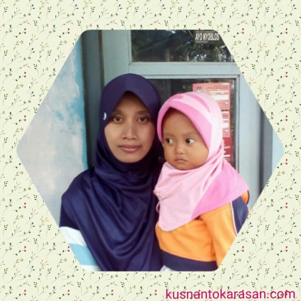 Ibu Rinawanti menggendong puteri anak keduanya 