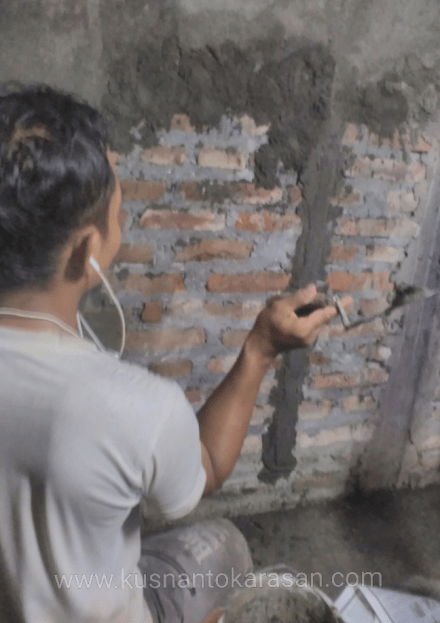 Disambitkan, satu cara menempelkan mortar ke tembok saat plester