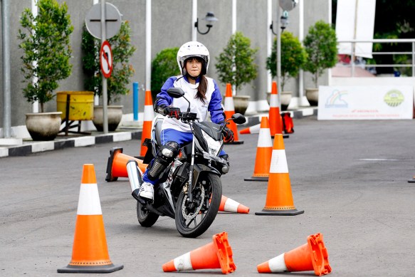 Salah satu lady biker dari komunitas Itasha region Jogja mencoba menyelesaikan materi slalom course dalam pelatihan safety riding bersama Astra Motor di Astra Motor Safety Riding Center (29/10). Dalam materi ini peserta dituntut untuk dapat menaklukkan berbagai jenis tikungan
